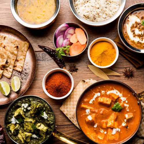 Indian Lunch or Dinner main course food in group includes Paneer Butter Masala, Dal Makhani, Palak Paneer, Roti, Rice etc, Selective focus